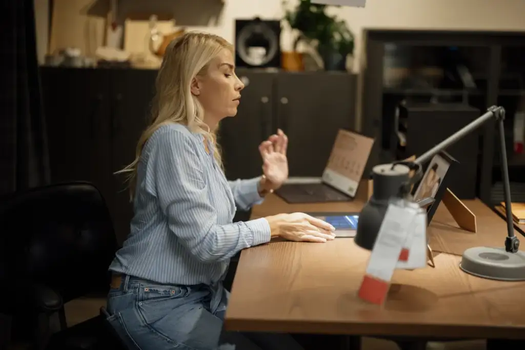 ChatGPT Dots: Woman sits at desk working on laptop in home office