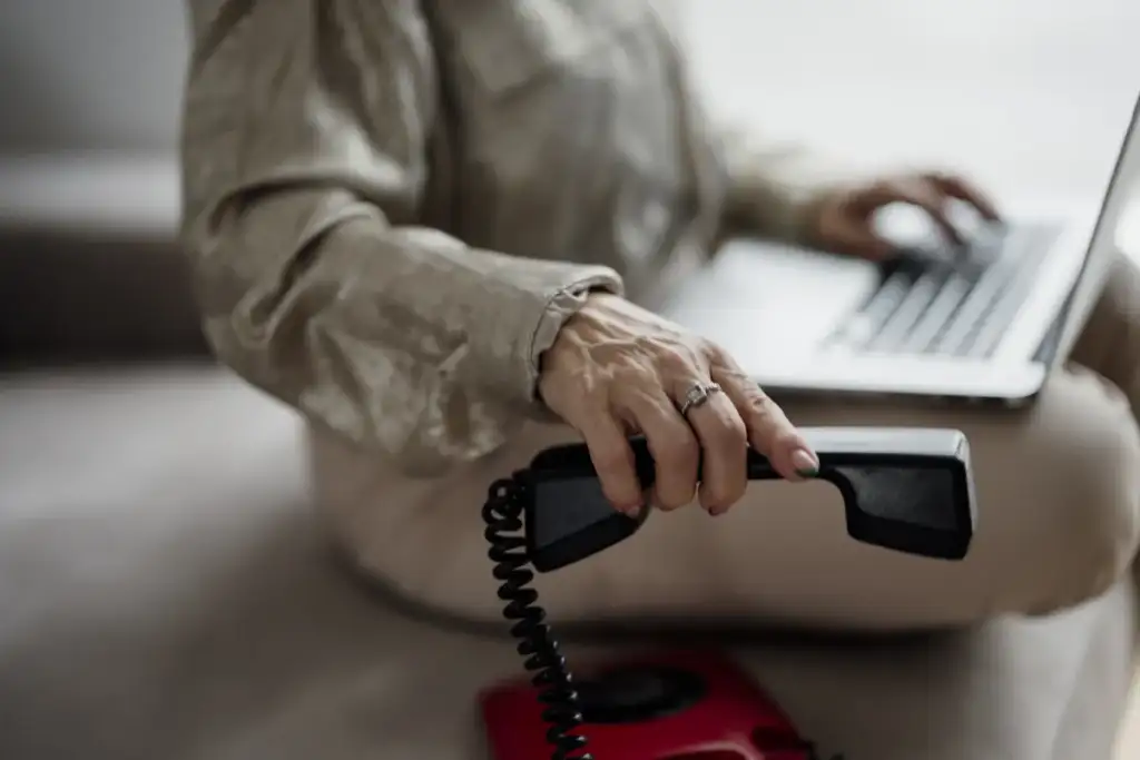 ChatGPT Dots use cases: Person using a laptop while holding a telephone receiver